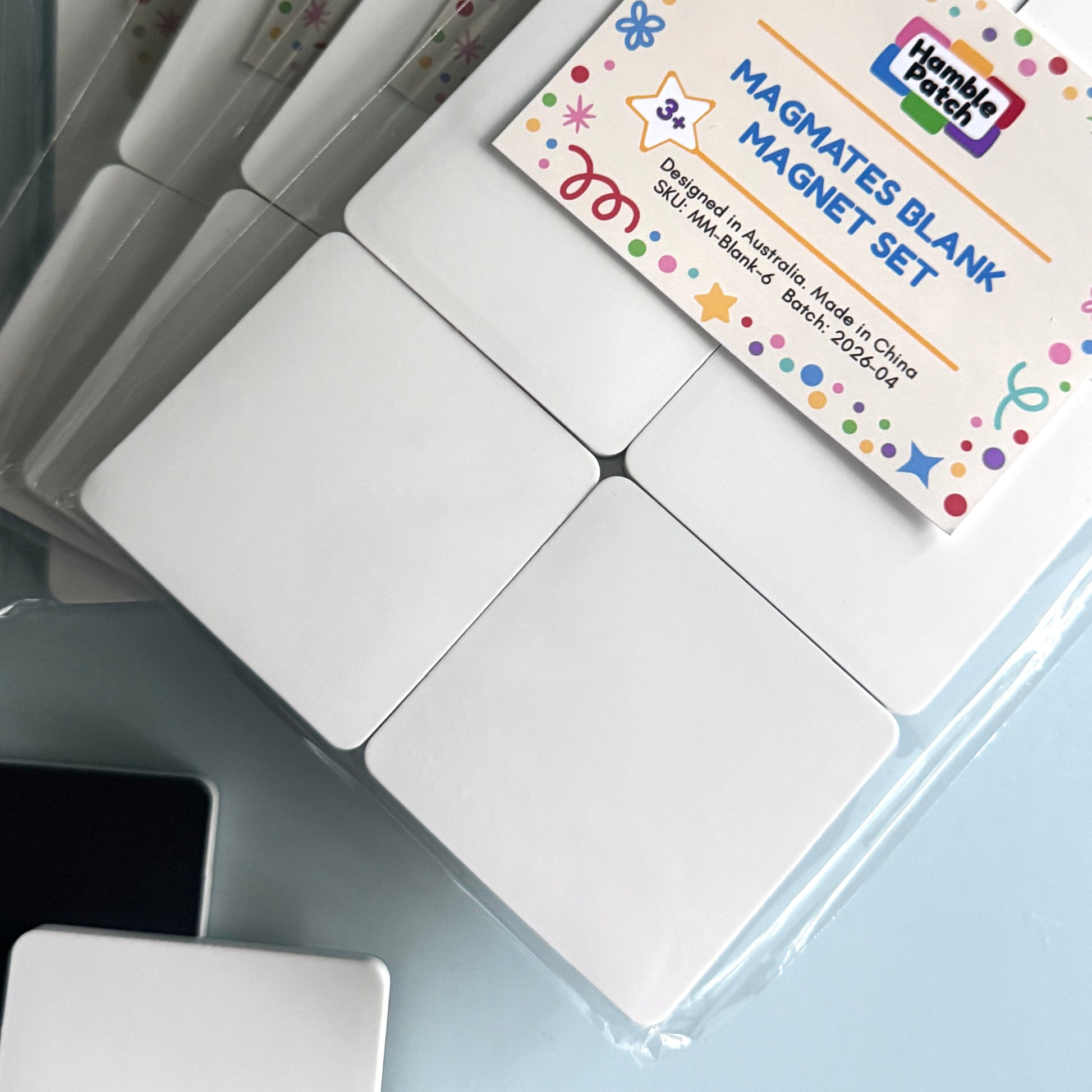 Blank magnetic tiles with a packaging label on a light blue surface