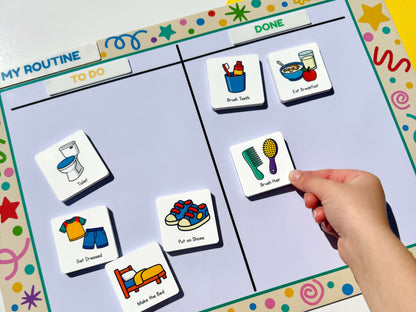 A close-up of a child's hand placing a colourful routine magnet (brush hair) onto a 'My Routine' daily magnetic board. The board features various illustrated magnetics representing daily tasks such as toilet, get dressed, brush hair, and put on shoes, set against a white background.