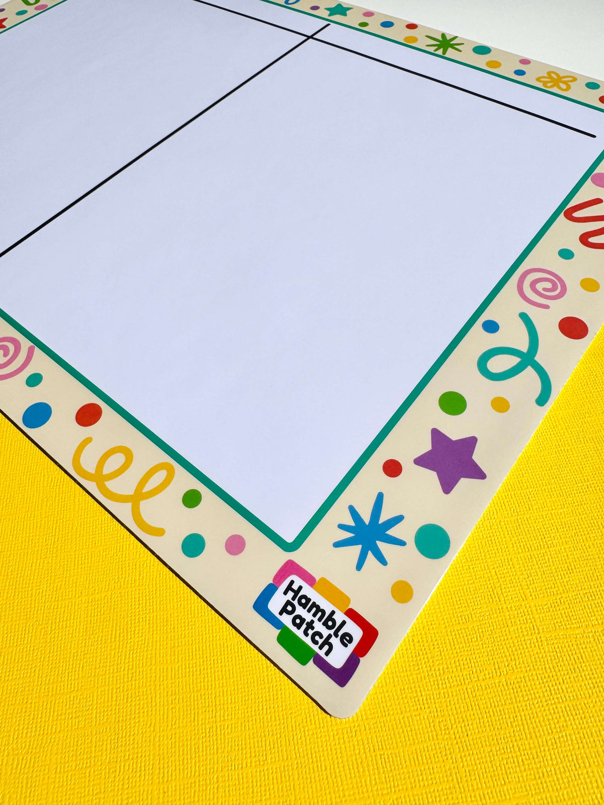 A square white magnetic board with a colourful decorative border, shown on a bright yellow textured surface. The border features multi-coloured doodles, stars, dots, and the Hamble Patch logo in the bottom corner.