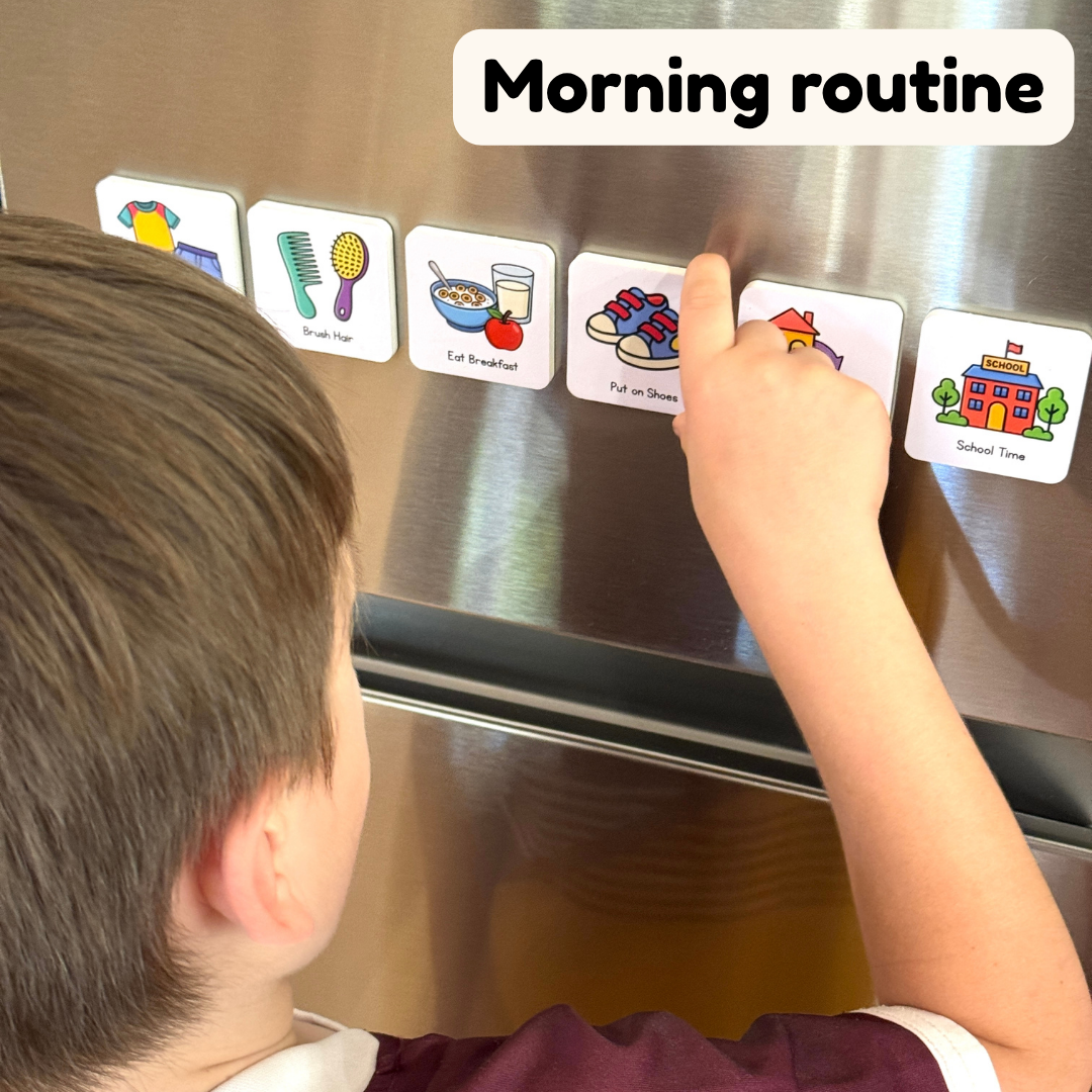 Child interacting with visual morning routine magnets on a refrigerator.