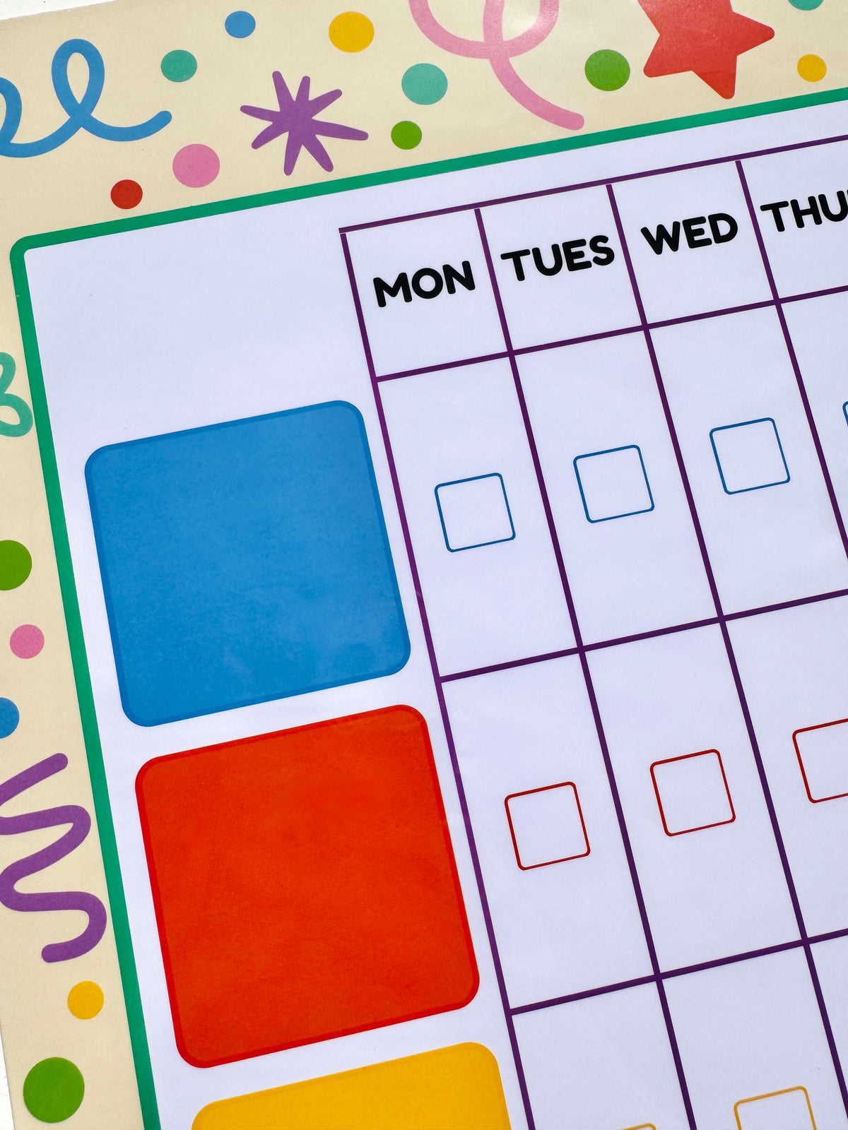 A close-up of a colourful weekly planner with columns labelled MON through THU and empty check boxes, plus large blue, orange, and yellow colour blocks on the left side.